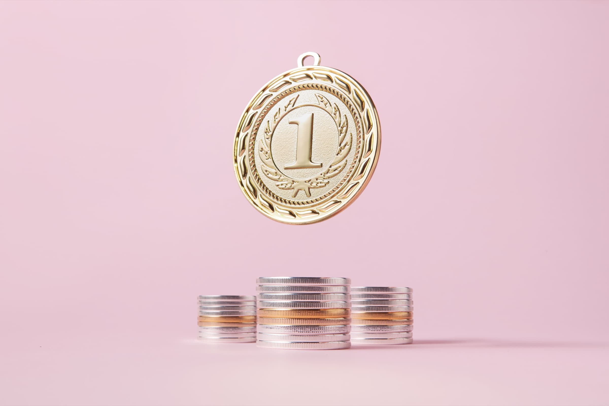 A gold medal above stacked coins, representing rewards as a support layer for healthy habits