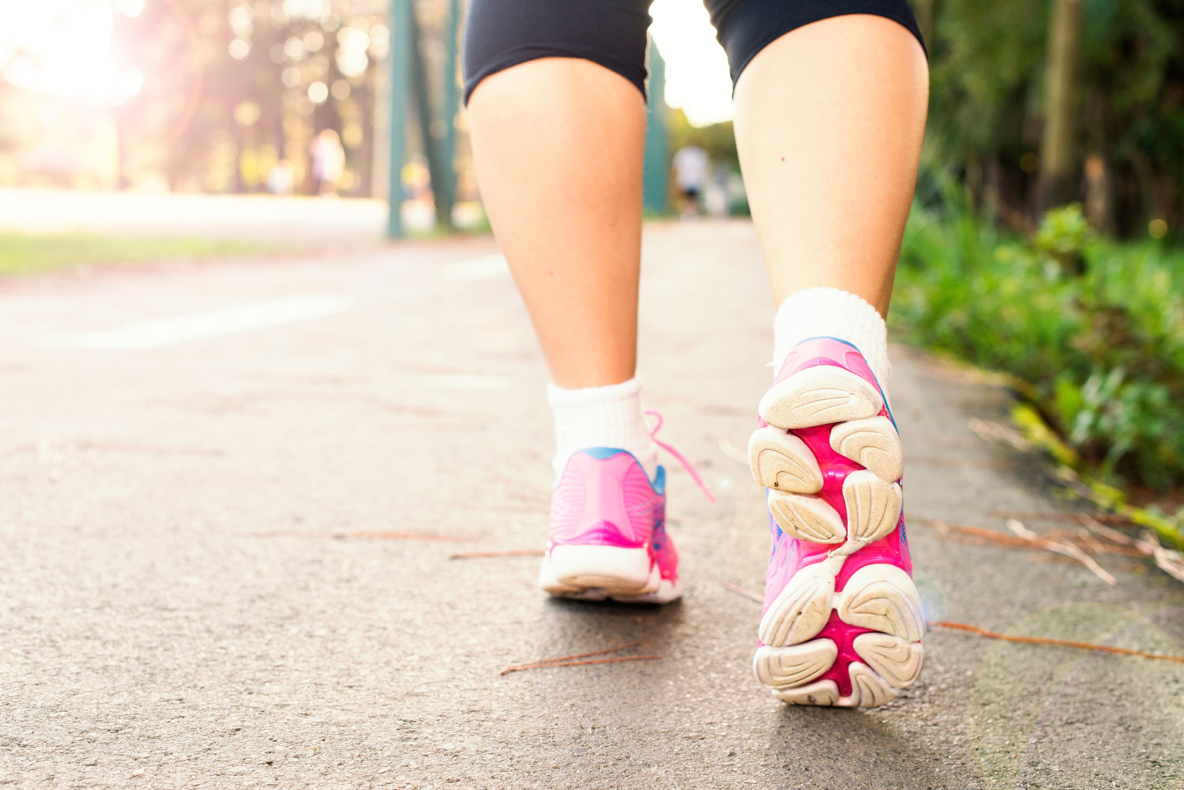 Close-up of a person walking outdoors in bright running shoes